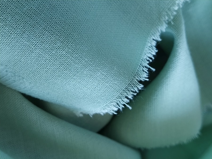 close-up-woolen-fabric-green-color-abstract-canvas-background-empty-template-thin-natural-fabric-wool-linen-edge-fabric-is-treated-against-chap.jpg