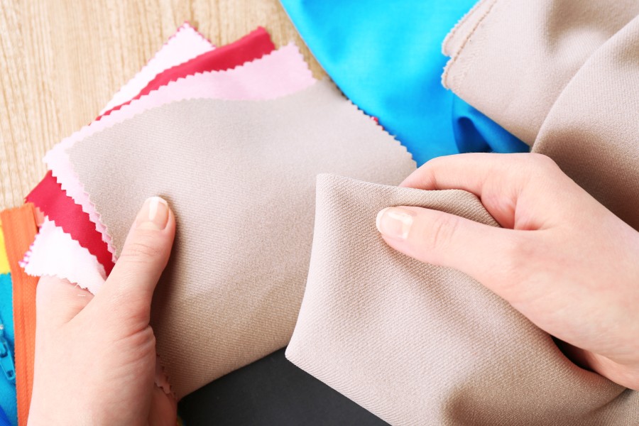colorful-fabric-samples-female-hands-wooden-table-background.jpg