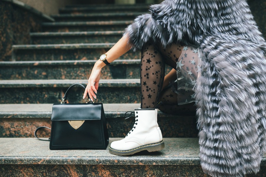 close-up-legs-white-boots-fashionable-woman-posing-city-warm-fur-coat-with-black-leather-bag.jpg
