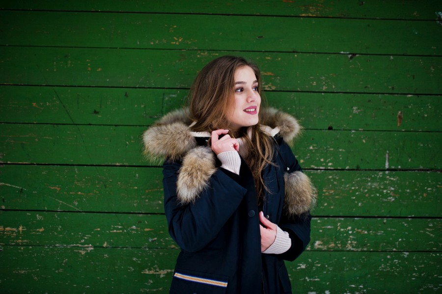 beautiful-brunette-girl-winter-warm-clothing-model-winter-jacket-against-green-wooden-background.jpg