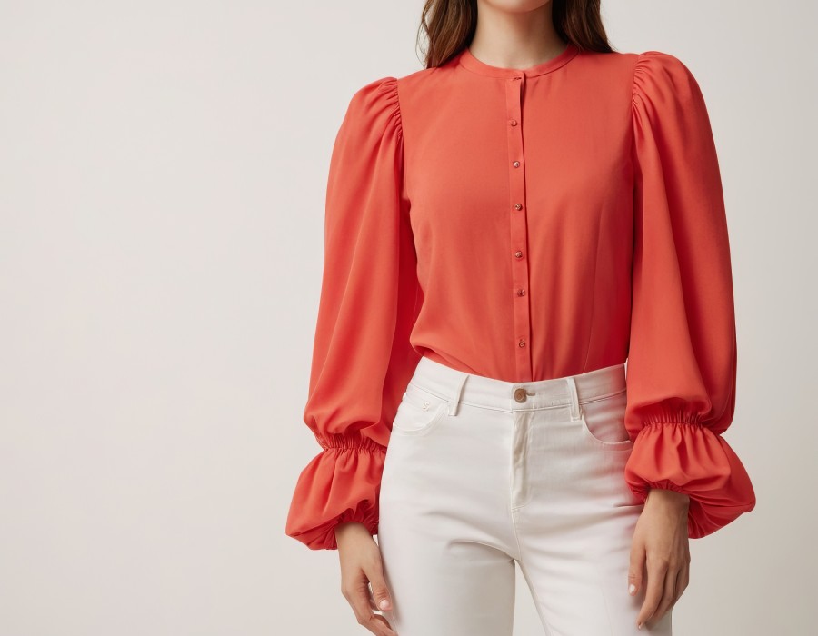 elegant-young-woman-wearing-vibrant-coral-blouse-with-puffed-sleeves-white-jeans.jpg