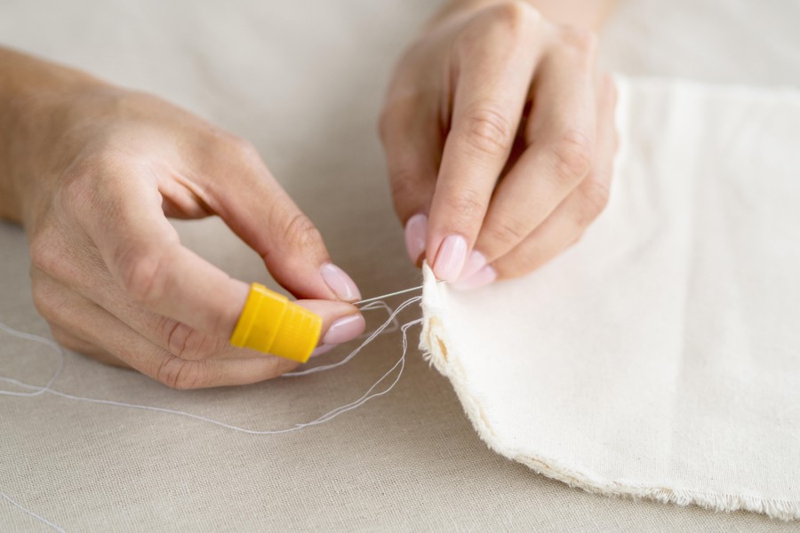 high-angle-woman-sewing-fabric.jpg