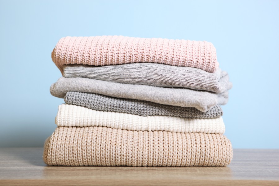 stack-warm-sweaters-table-colored-background.jpg