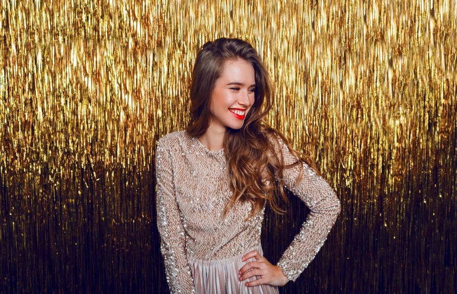elegant-celebrating-woman-with-surprise-face-standing-golden-sparkling.jpg
