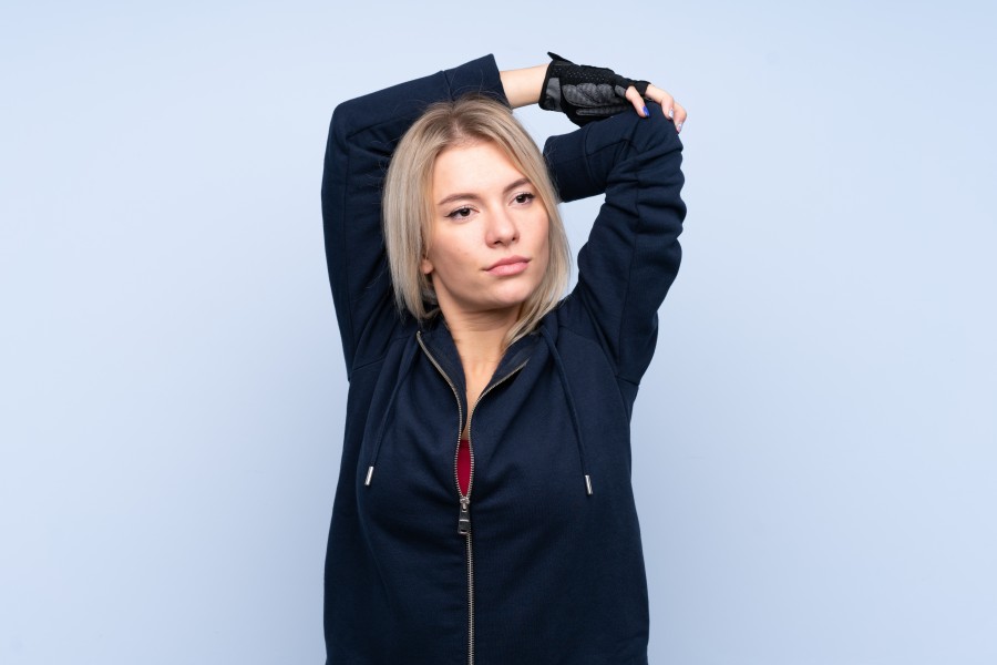 young-sport-blonde-woman-isolated-blue-wall-stretching.jpg